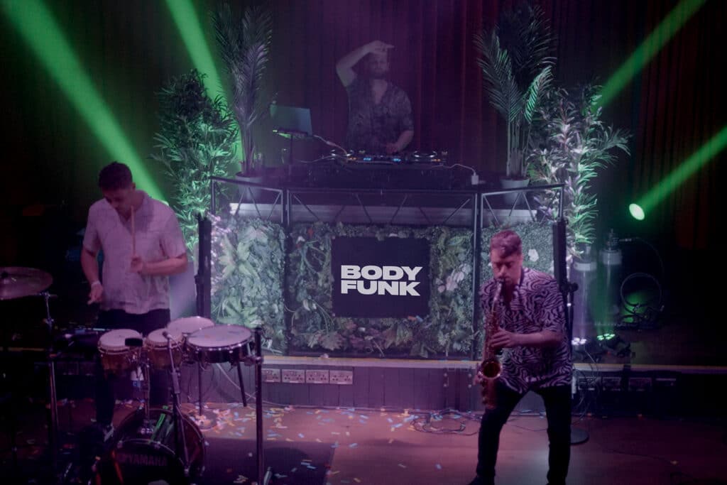 Live BODY FUNK performance with tropical stage design in Index/Opium Dublin Nightclub. Sax drums and DJ on big stage.